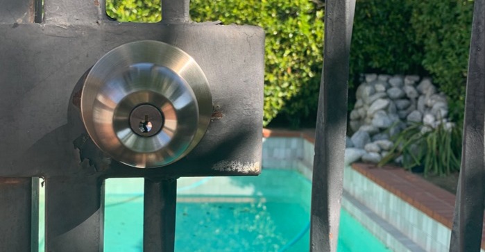 A newly installed gate lock in an outdoor pool setting.