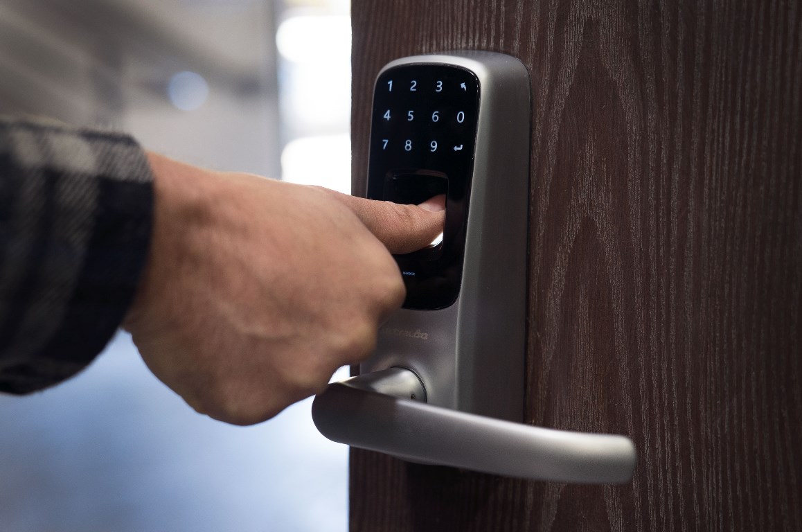 A person using their thumb to unlock a biometric lock.